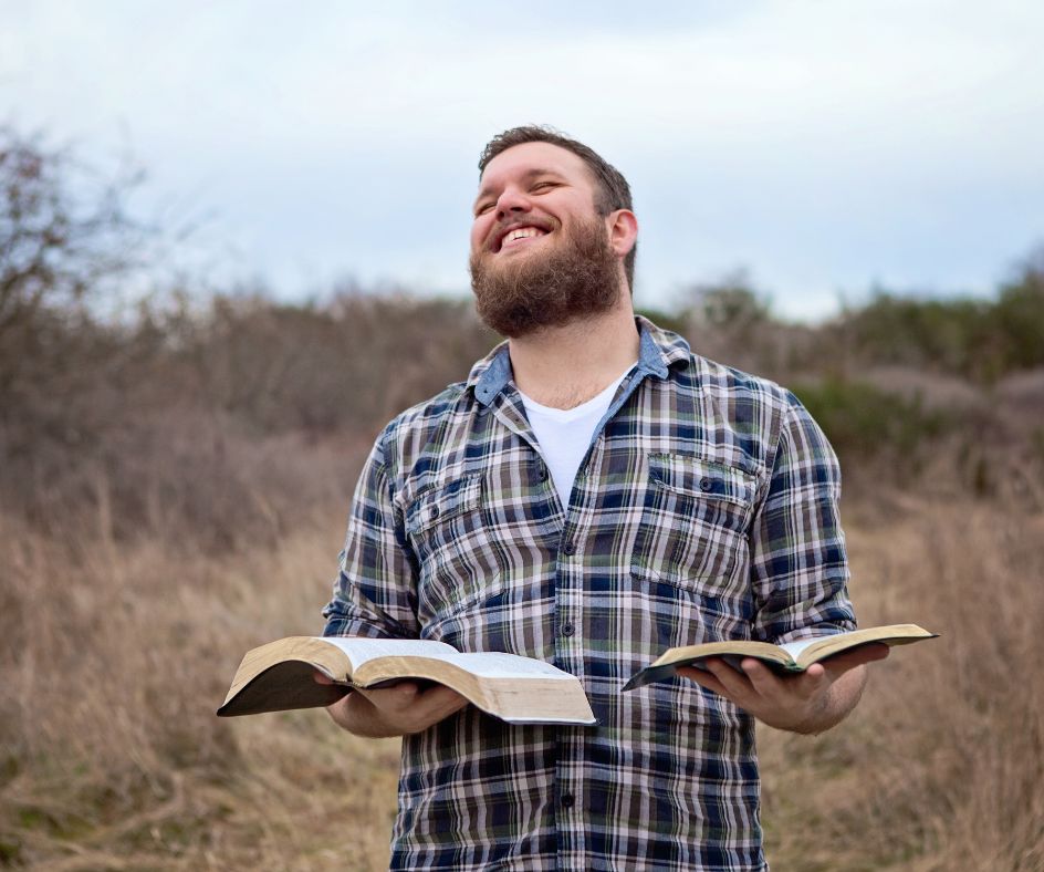 man-holding-bibles-in-the-middle-of-ground.jpg